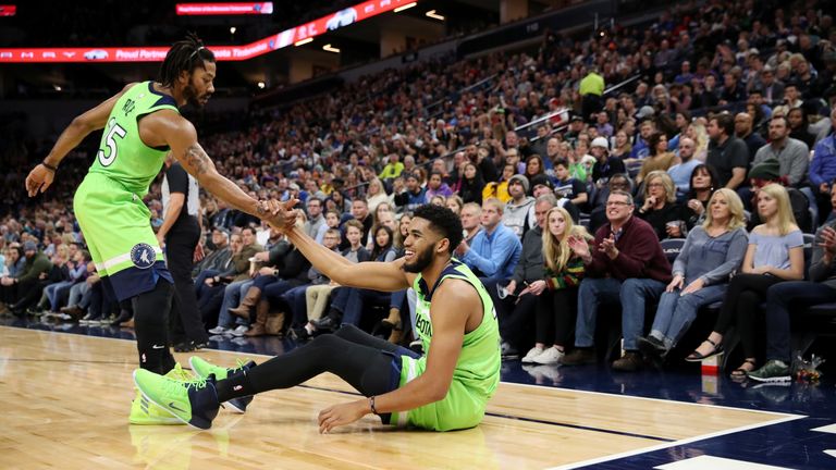 Derrick Rose #25 of the Minnesota Timberwolves helps teammate Karl-Anthony Towns #32 of the Minnesota Timberwolves from the floor during the game against the Denver Nuggets on November 24, 2018 at Target Center in Minneapolis, Minnesota. 