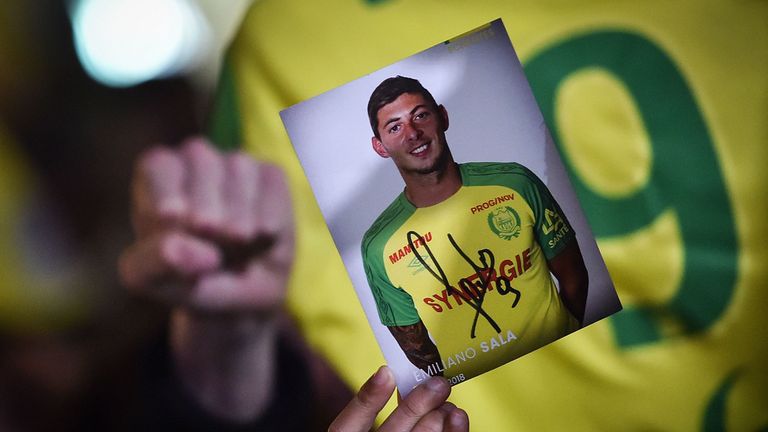 A member of the public holds up a photograph of missing footballer Emiliano Sala during a vigil in Nantes, western France
