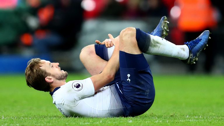 Harry Kane clutches his left leg after picking up an injury