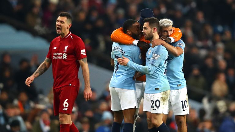 Manchester City celebrate victory on a difficult night for Dejan Lovren of Liverpool