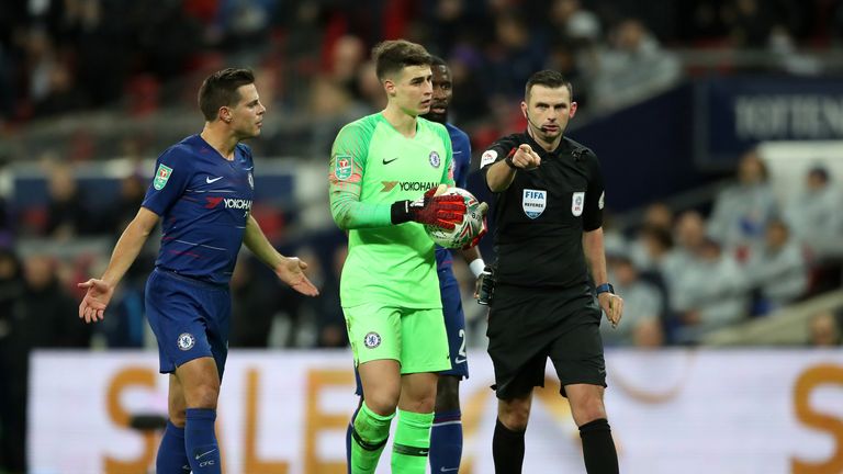 Match referee Michael Oliver points to the penalty spot after a foul by Chelsea goalkeeper Kepa Arrizabalaga during the Carabao Cup, semi final match at Wembley, London
