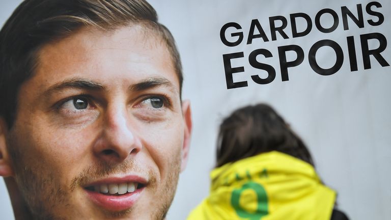 An FC Nantes supporter stands beside a portrait of Emiliano Sala outside the club's training centre