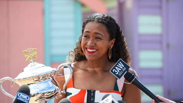 Japan's Naomi Osaka speaks holding the championship trophy at the Brighton Beach in Melbourne on January 27, 2019, a day after her victory against Czech Republic's Petra Kvitova in the women's singles final at the Australian Open tennis tournament.