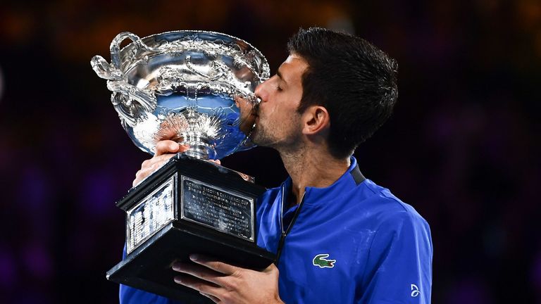 Serbia's Novak Djokovic celebrates with the championship trophy during the presentation ceremony after his victory against Spain's Rafael Nadal in the men's singles final on day 14 of the Australian Open tennis tournament in Melbourne on January 27, 2019.