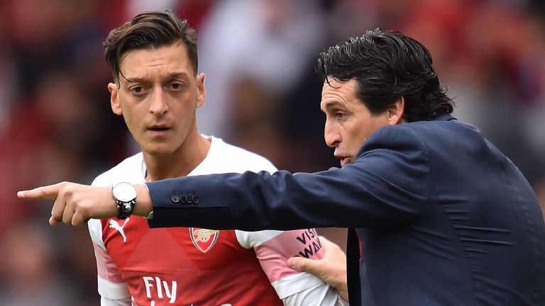 Arsenal's Spanish head coach Unai Emery gestures to Arsenal's German midfielder Mesut Ozil (L) on the touchline during the English Premier League football match between Arsenal and Manchester City at the Emirates Stadium in London on August 12, 2018