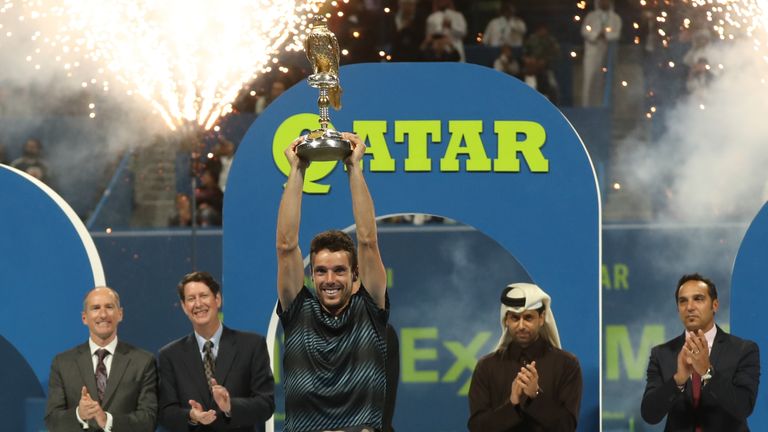 Spain's Roberto Bautista Agut (front) raises the trophy after winning against Czech Republic's Tomas Berdych the ATP Qatar Open tennis final match in Doha on January 5, 2019