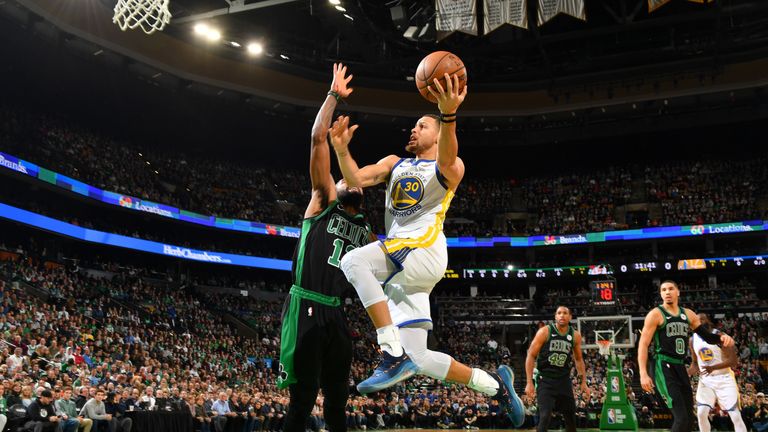 Stephen Curry fights his way to the hoop for a lay-up against the Celtics
