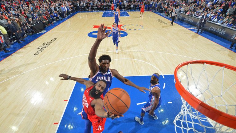 Joel Embiid attempts to block James Harden's shot at the rim