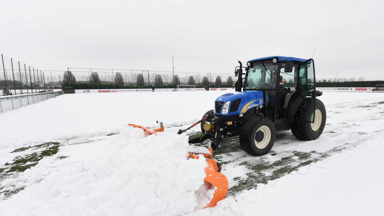 Groundsmen try to clear snow at Arsenal&#39;s London Colney training ground on Friday morning
