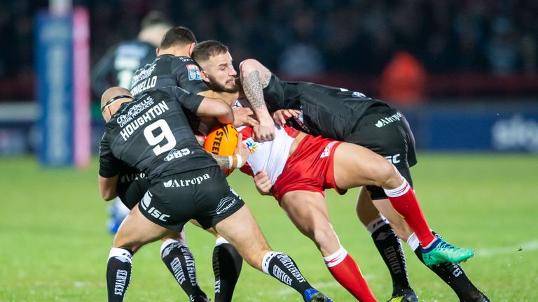 Hull KR's Ben Crooks is tackled by Hull FC's Danny Houghton and Mark Minichiello
