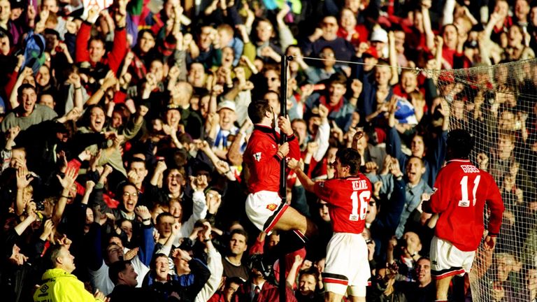 Cantona celebrates his goal with a famous twirl around a pole in front of fans