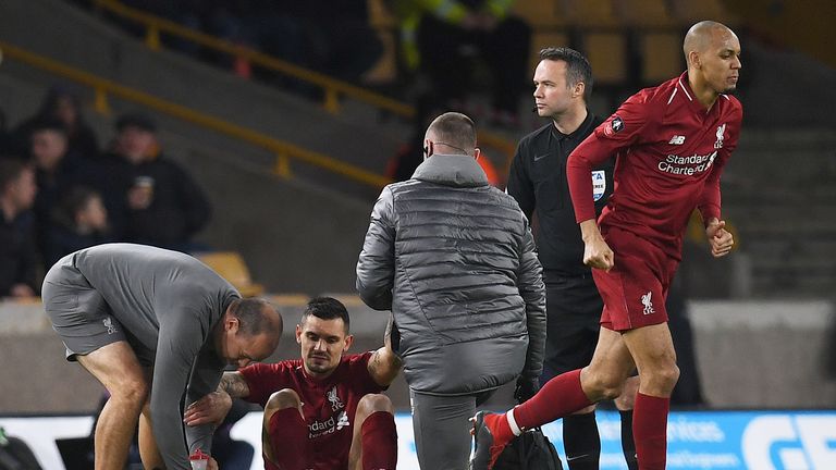 Dejan Lovren is helped to his feet before leaving the pitch injured during Liverpool's FA Cup third round match against Wolves at Molineux