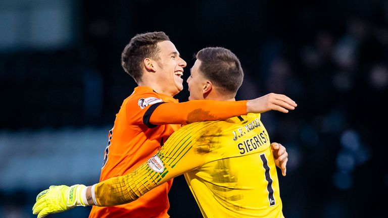 Dundee United goalkeeper Benjamin Siegrist celebrates with Charlie Seamanl (L) at full-time