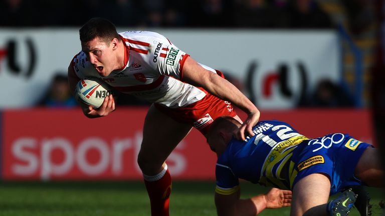 Hull KR's Joel Tomkins is tackled by Warrington's Jack Hughes.