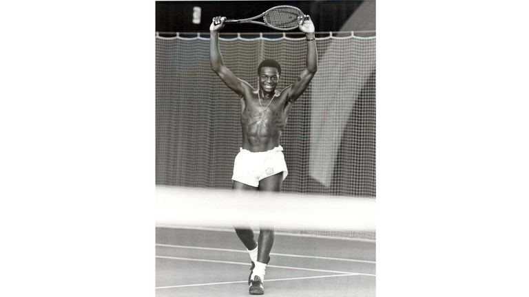 Norwich City's England U21 striker Justin Fashanu celebrates a victory over Chris Woods at a tennis court near  Zurich during the England Summer Tour of 1981