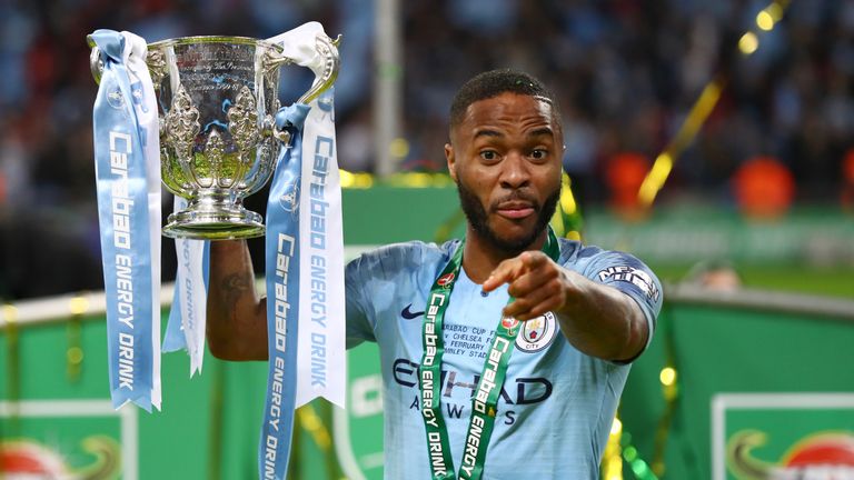 Raheem Sterling celebrates with the trophy after Manchester City's defeat of Chelsea in the Carabao Cup Final at Wembley Stadium