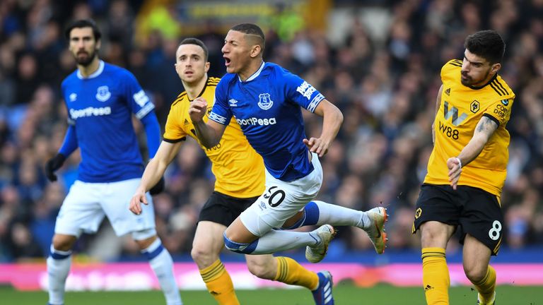 Richarlison goes down in a challenge with Ruben Neves