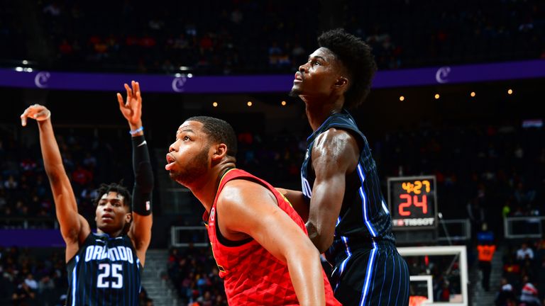 Omari Spellman of the Atlanta Hawks and Jonathan Isaac of the Orlando Magic fight for position for the rebound