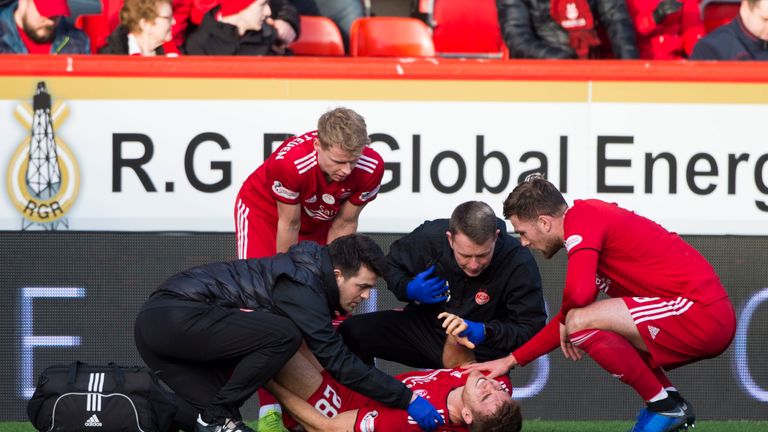 Aberdeen's Tommie Hoban was treated for a knee injury on the pitch