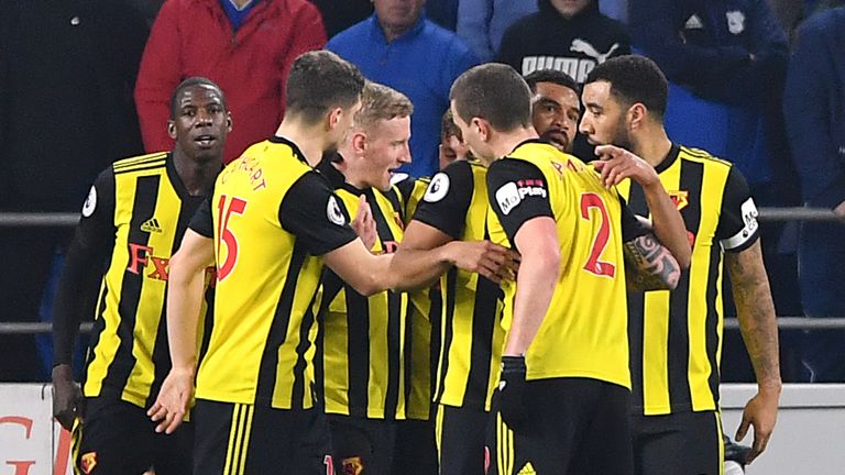 Watford's Abdoulaye Doucoure (hidden) celebrates scoring his side's first goal of the game with team-mates during the Premier League match at the Cardiff City Stadium, 22 February 2019