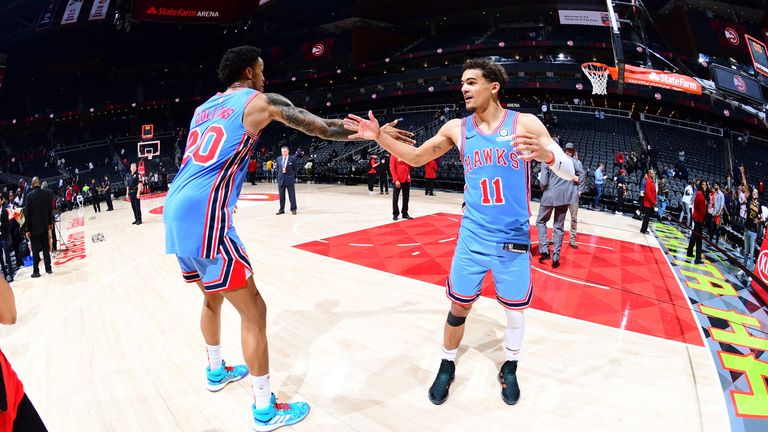 John Collins and Trae Young celebrate Atlanta's overtime win over the Minnesota Timberwolves