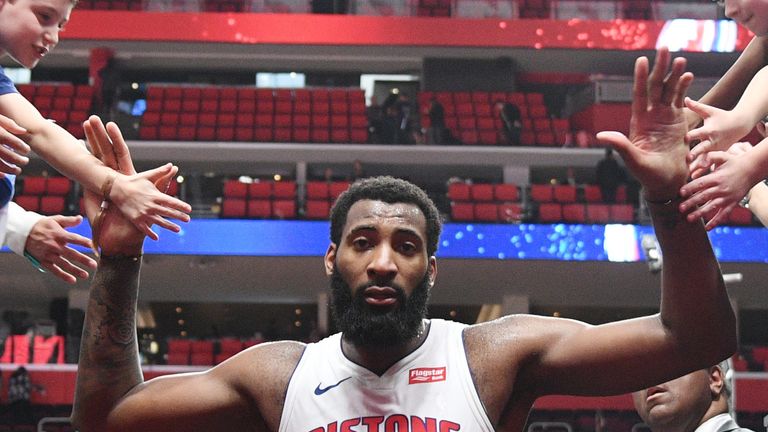 Andre Drummond high-fives Pistons fans after a win