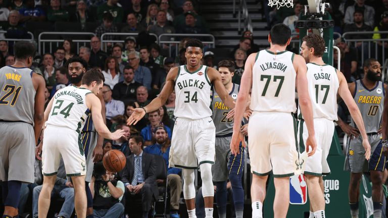 Giannis Antetokoumpo low-fives his Bucks team-mates