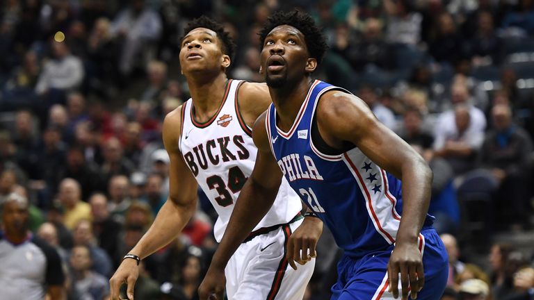 Giannis Antetokounmpo and Joel Embiid battle for a rebound