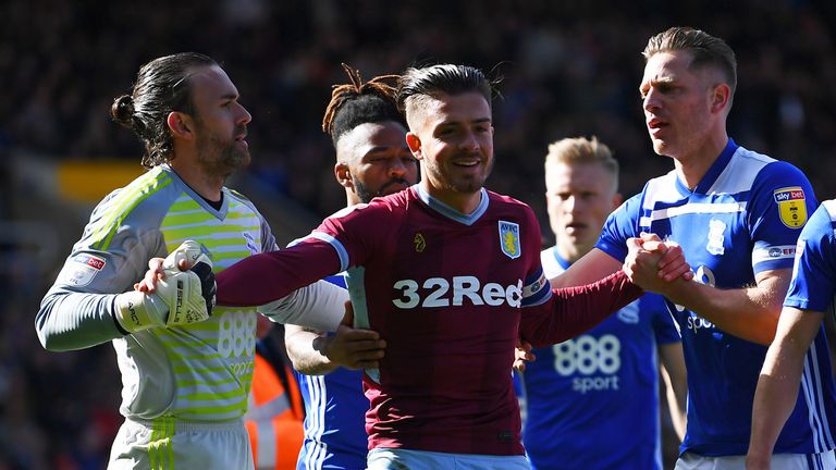 Jack Grealish of Aston Villa is helped up by Lee Camp and Michael Morrison of Birmingham City after colliding with a pitch invader during the Sky Bet Championship match between Birmingham City and Aston Villa at St Andrew's Trillion Trophy Stadium on March 10, 2019 in Birmingham, England