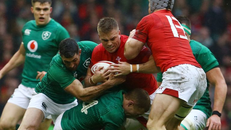 Gareth Anscombe is wrapped up by the Ireland defence