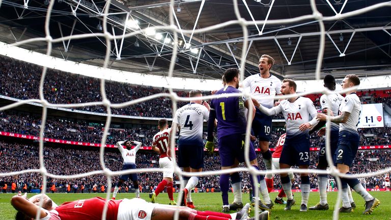Hugo Lloris celebrates with team-mates after saving a late penalty whilst a dejected Pierre-Emerick Aubameyang lies nearby