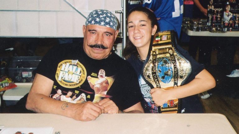 Bayley - predicting her future world championship reigns with a replica belt - meets former WWF world champ the Iron Sheik