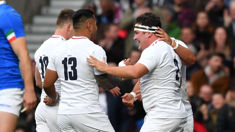 Jamie George celebrates with team-mates after scoring England's first try against Italy