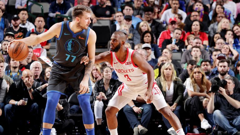 Luka Doncic of the Dallas Mavericks handles the ball against Chris Paul of the Houston Rockets