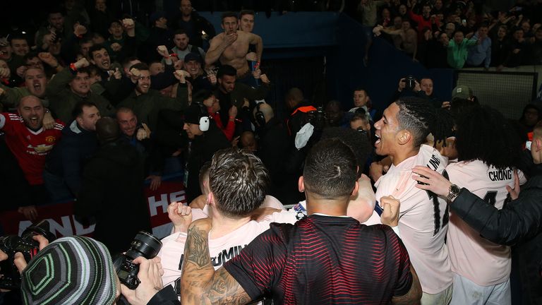 Manchester United's players celebrate with fans after the famous victory