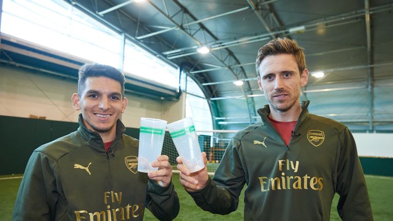 Nacho Monreal and Lucas Torreria with the reusable plastic cups to be trialled during Arsenal vs Man Utd on Sunday