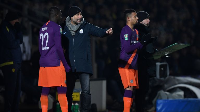 Manchester City's Spanish manager Pep Guardiola (C) talks with Manchester City's French defender Benjamin Mendy (L) as he waits with Manchester City's Brazilian striker Gabriel Jesus to be substituted on during the English League Cup second leg semi-final football match between Burton Albion and Manchester City at the Pirelli Stadium in Burton-upon-Trent, central England on January 23, 2019. 