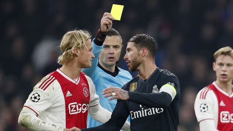 Referee Damir Skomina shows Sergio Ramos a yellow card during the UEFA Champions League Round of 16, First Leg between Ajax and Real Madrid