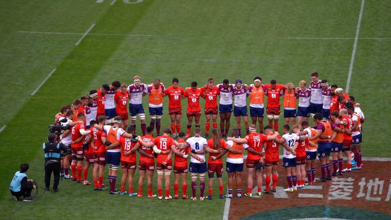 Players huddle to observe a minute of silence for the Christchurch terror attack victims prior to the Super Rugby match between Sunwolves and Reds 