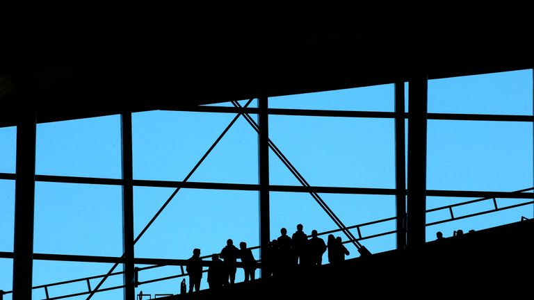 Supporters are silhouetted against the backdrop of Tottenham Hotspurs&#39; new stadium during the first official test event on Sunday