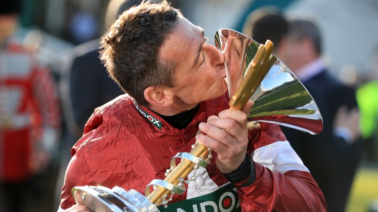 Jockey Davy Russell celebrates with the trophy after Tiger Roll's second Grand National win