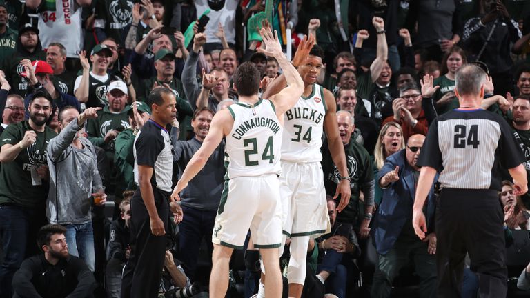 Giannis Antetokounmpo high-fives team-mate Pat Connaughton