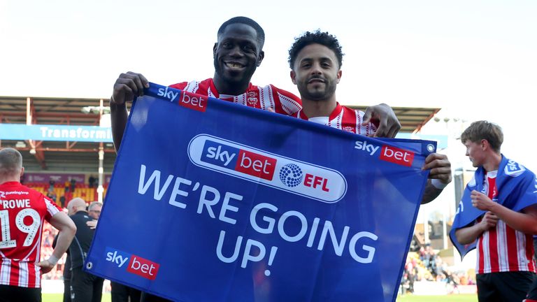 Lincoln City's Bruno Andrade (right) and John Akinde celebrate being promoted after the Sky Bet League Two match at Sincil Bank