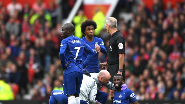 Antonio Rudiger receives treatment after going down holding his left knee during the 1-1 draw with Manchester United at Old Trafford