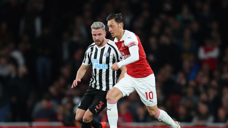 Mesut Ozil tussles for the ball