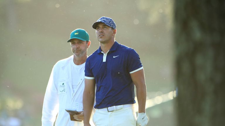 Brooks Koepka of the United States and caddie Ricky Elliott look on from the 17th hole during the first round of the Masters at Augusta National Golf Club on April 11, 2019 in Augusta, Georgia. (
