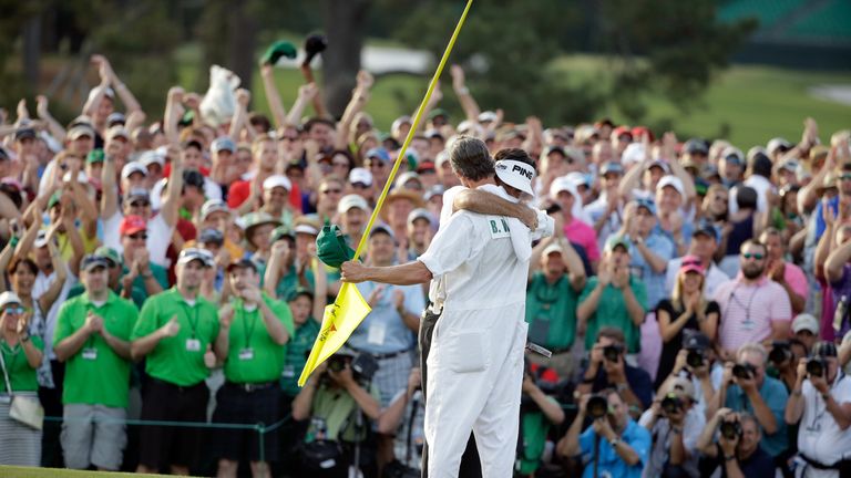 Bubba Watson of the United States hugs his caddie Ted Scott on the 18th green after winning the 2014 Masters 