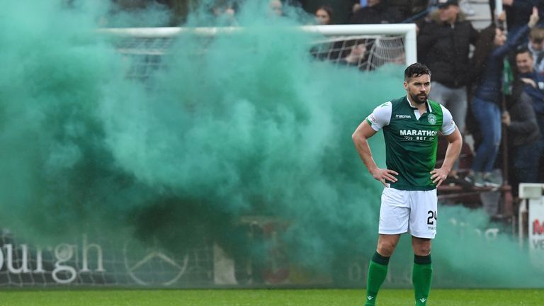 Hibernian’s Darren McGregor looks on as a smoke bomb is let off behind him