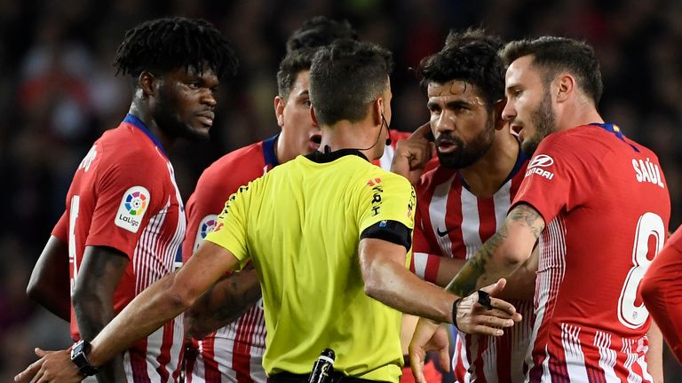 Atletico Madrid's Spanish forward Diego Costa (2R) talks with Spanish referee Gil Manzano prior to receiving a red card during the Spanish league football match between FC Barcelona and Club Atletico de Madrid at the Camp Nou stadium in Barcelona on April 6, 2019.