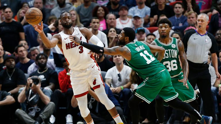 Dwyane Wade of the Miami Heat throws a pass around Kyrie Irving of the Boston Celtics 